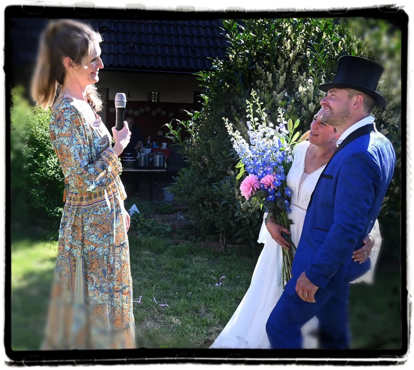 Freie Trauung im Garten — Denise hält die Rede, das Brautpaar lauscht.